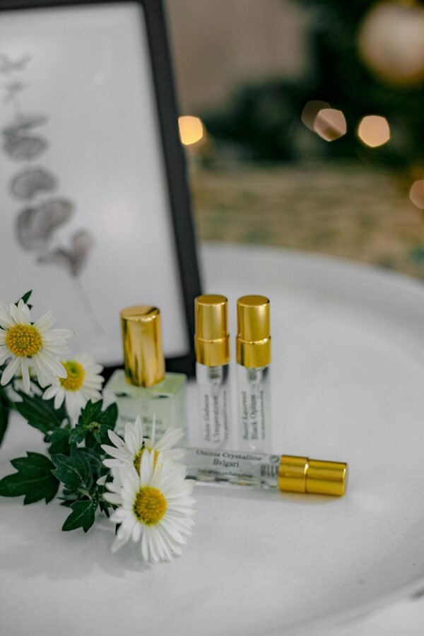 pexels-photo-20472874-20472874 A stylish composition of perfume bottles with daisies and golden caps, perfect for beauty concepts.